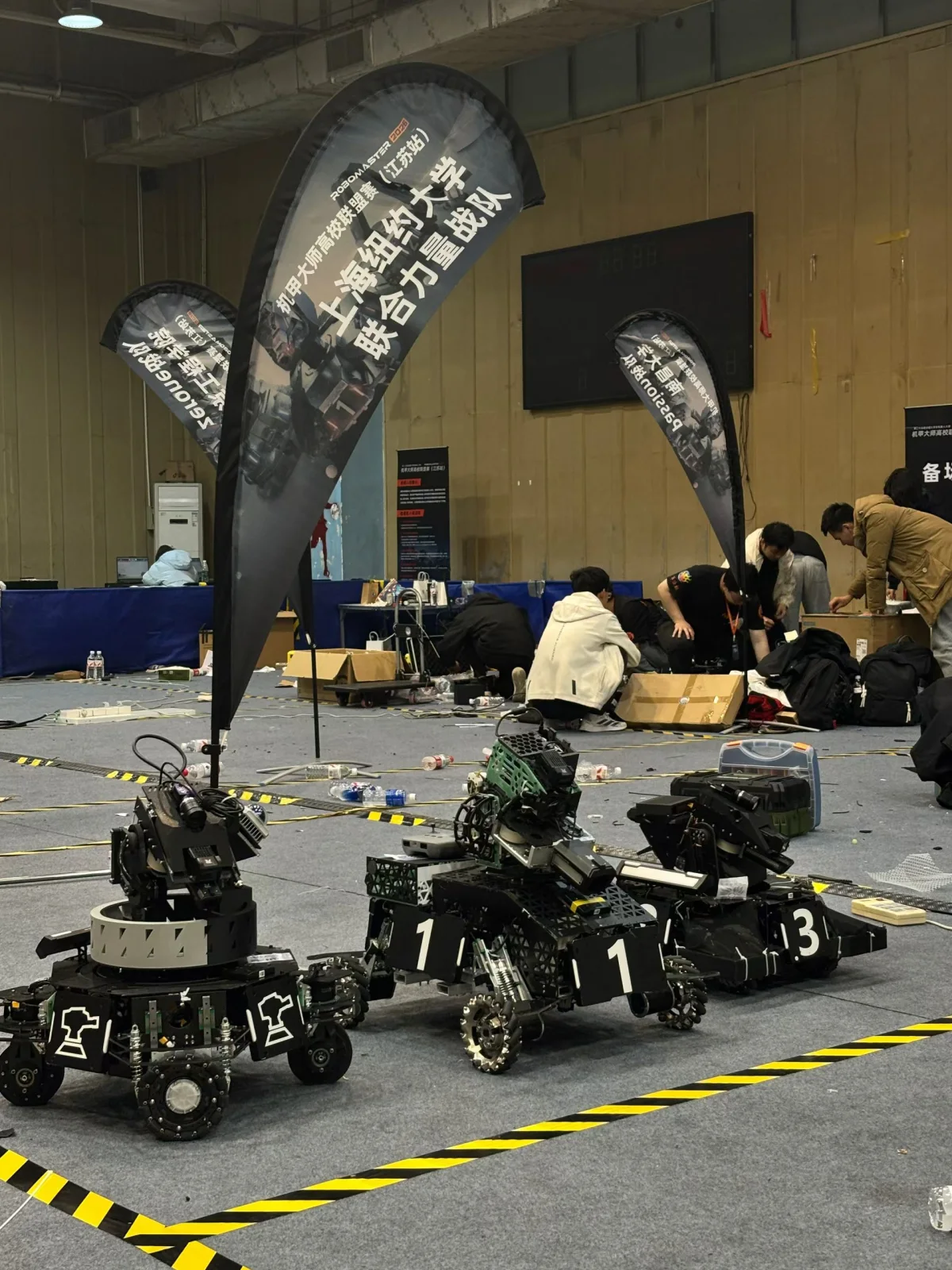 NYU Shanghai RoboMaster robots at a competition venue.