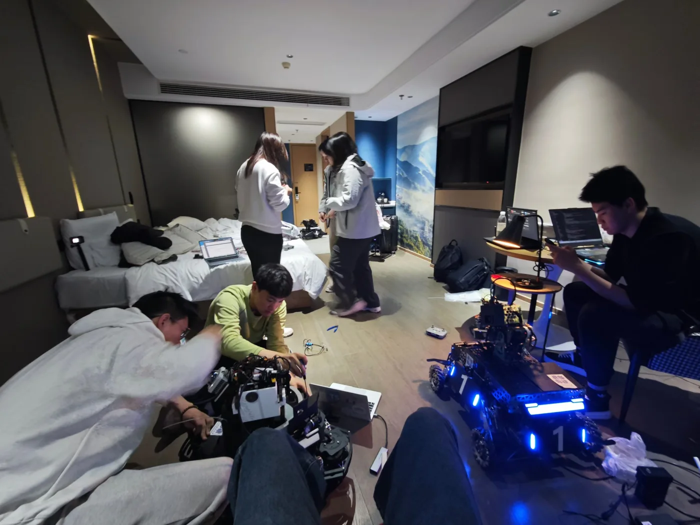 The team debugging multiple RoboMaster robots late at night.