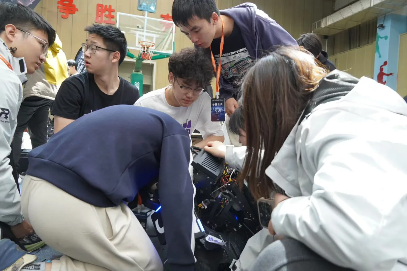 Team members troubleshooting a RoboMaster robot in the pit.
